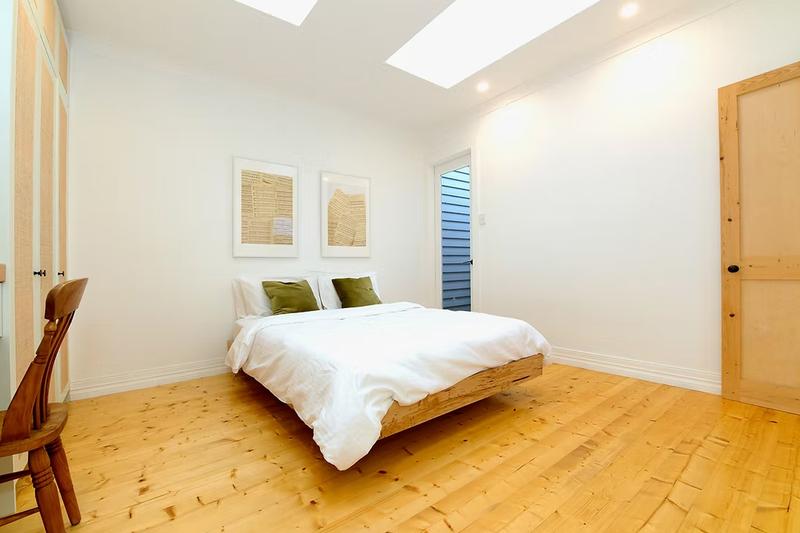 Bedroom with skylights and polished floorboards