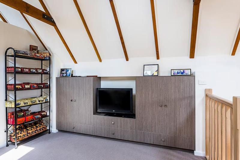 Entertainment unit on mezzanine floor of garage conversion to living space