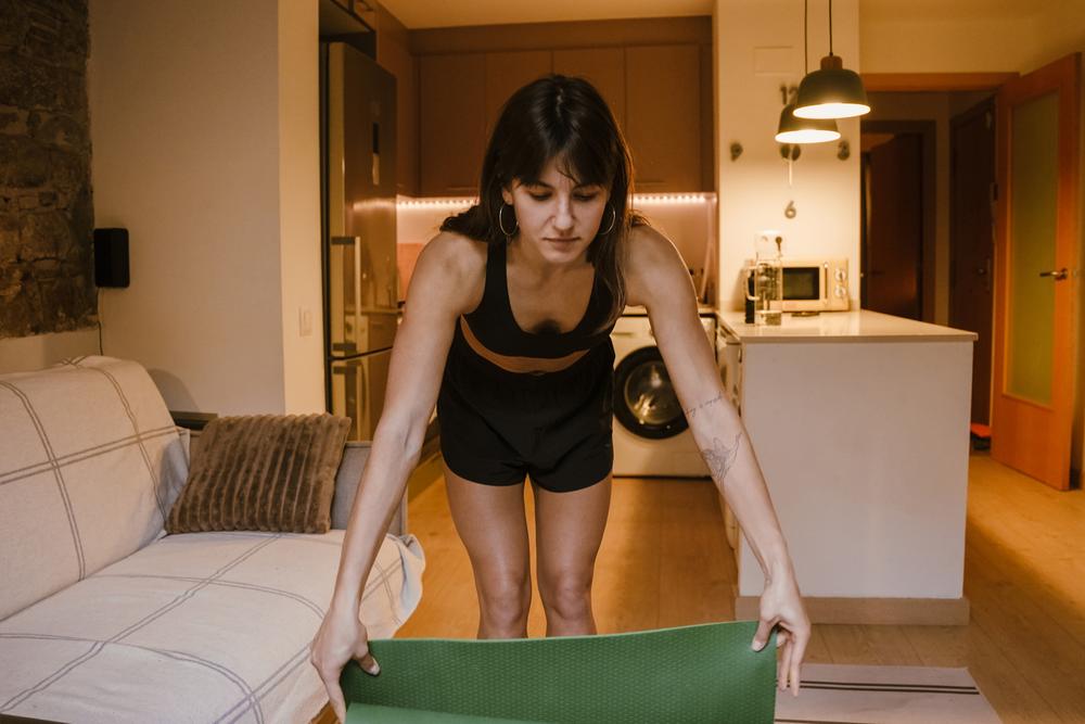 Packing away a yoga mat in the kitchen